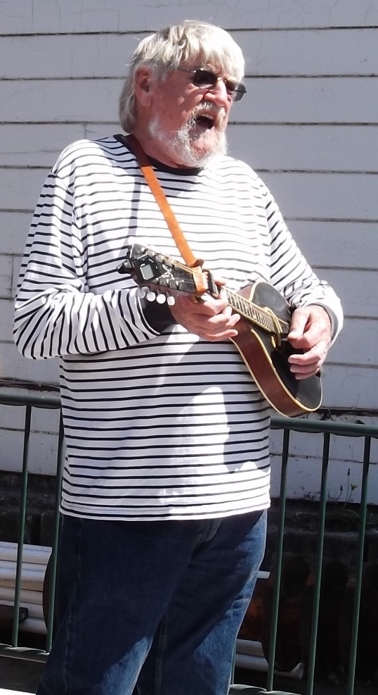 Image of Dick singing and playing mandolin.